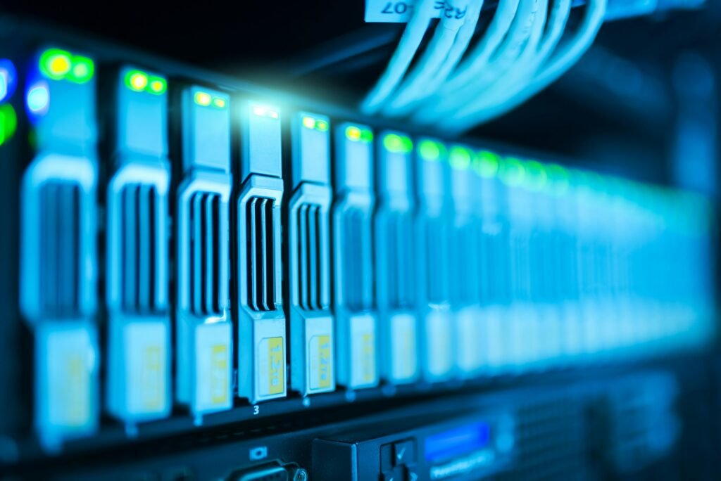 Close-up of server racks with glowing LED lights and network cables in a data center.